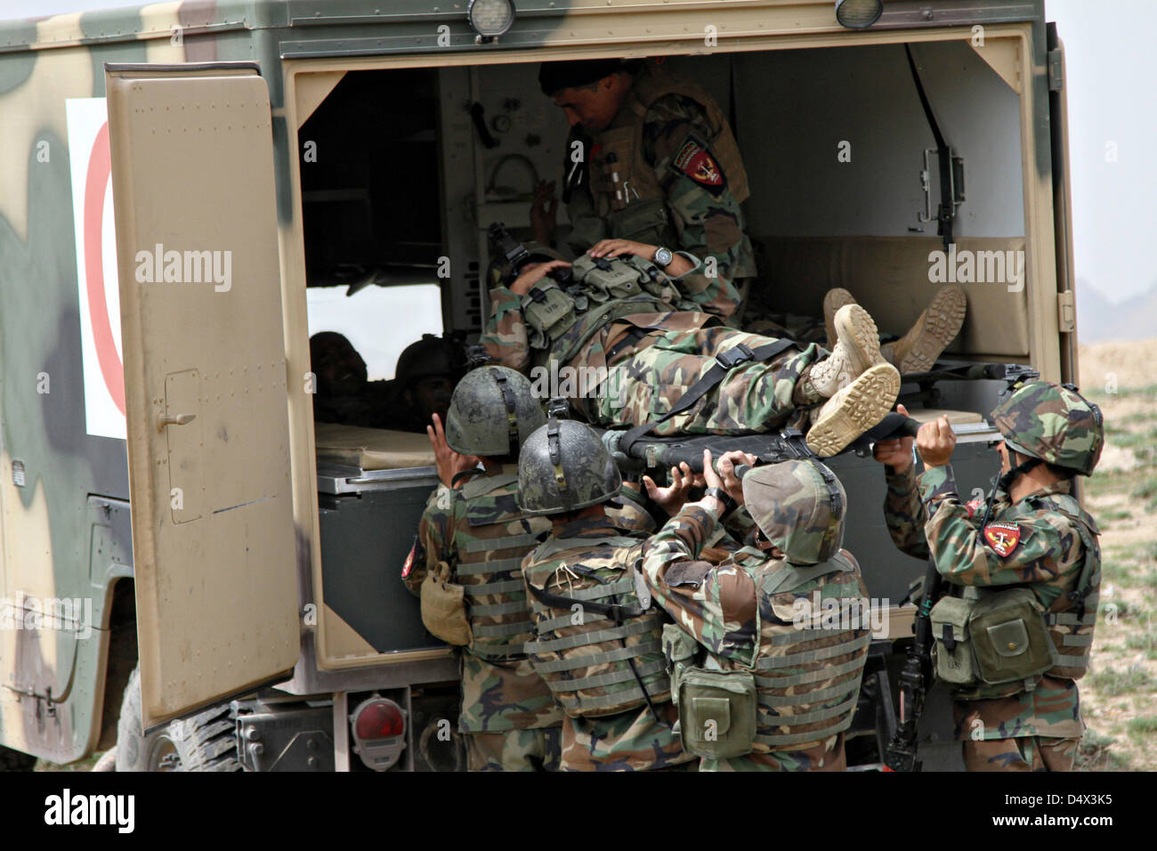 Afghan Commandos with Special Operations Kandak load a simulated casualty during a live fire exercises March 18, 2013 in Herat province, Afghanistan. Stock Photo