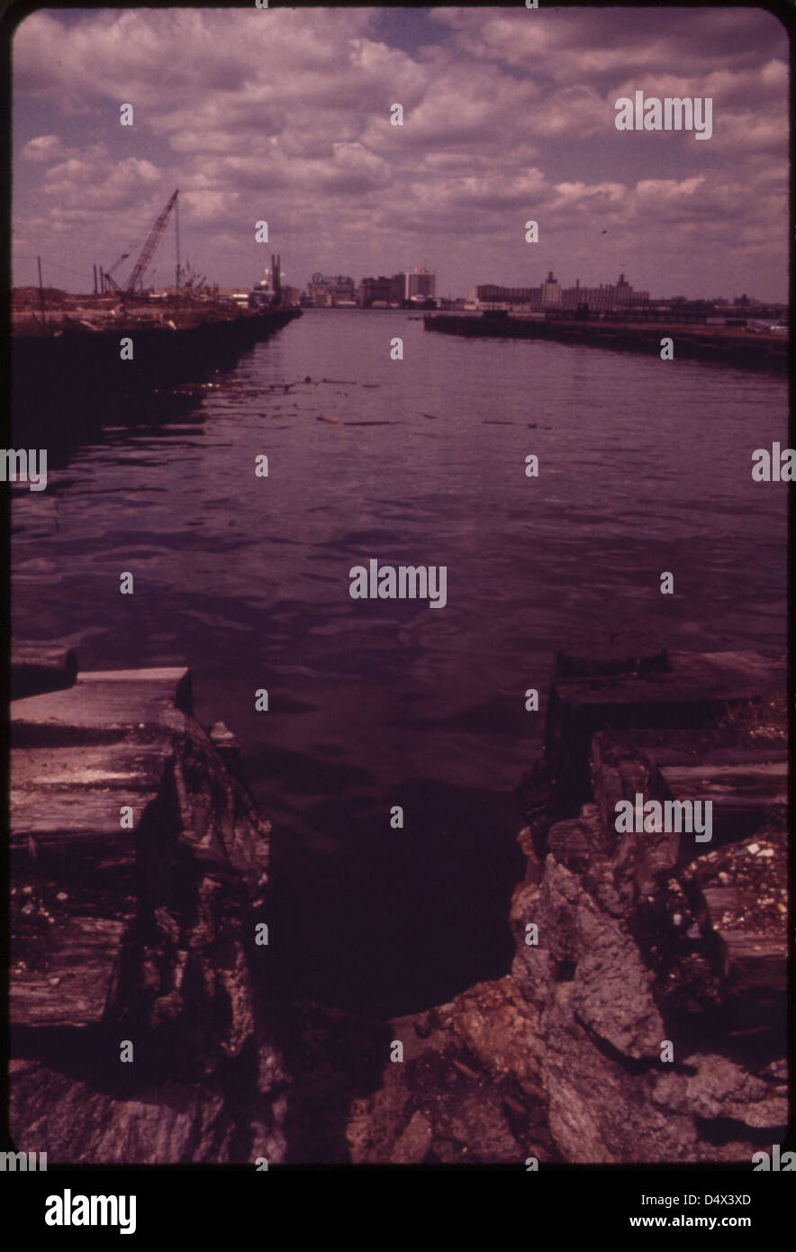 Eroded Sea Wall on West Street Opposite Lower Manhattan's World Trade Center, Looking Toward the New Jersey Shore of the Hudson River. Crane at Left Is on the Site of the Battery Park Development 05/1973 Stock Photo