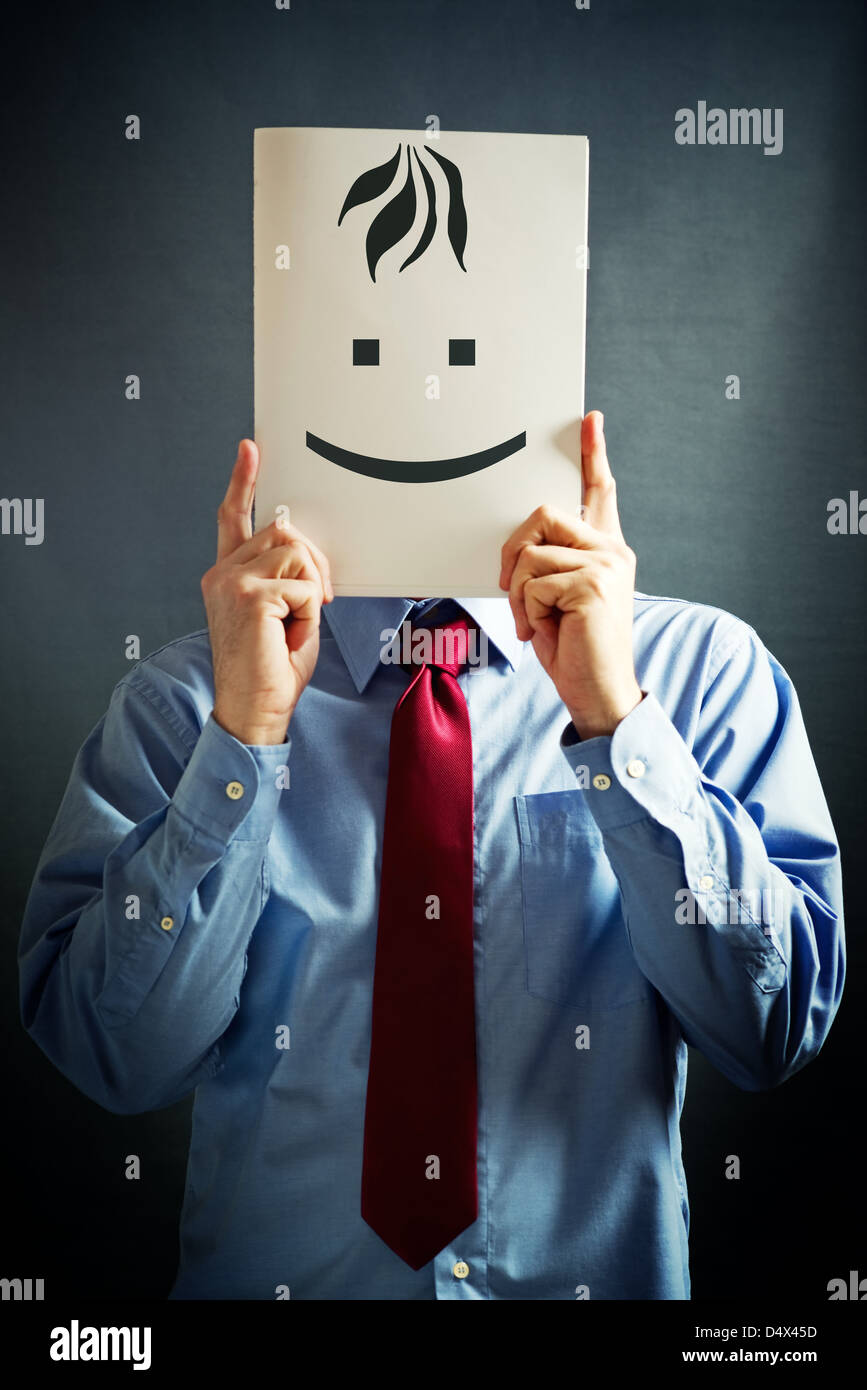 Businessman in blue shirt holding white paper card with happy face on it Stock Photo