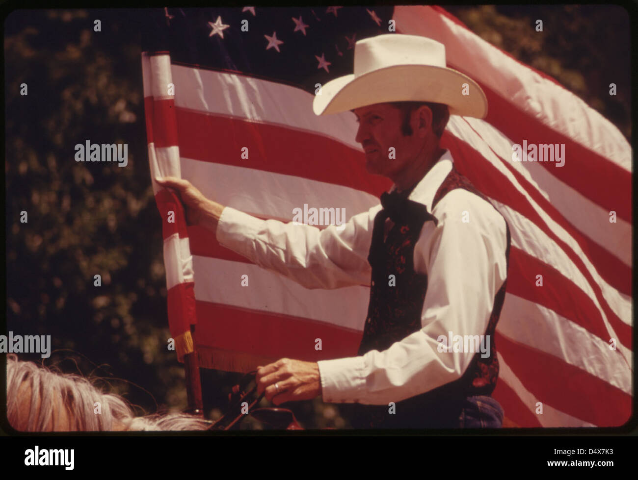 Rider with an American Flag on Horseback in a Parade on the Main Street of Cottonwood Falls, Kansas, near Emporia...06/1974 Stock Photo