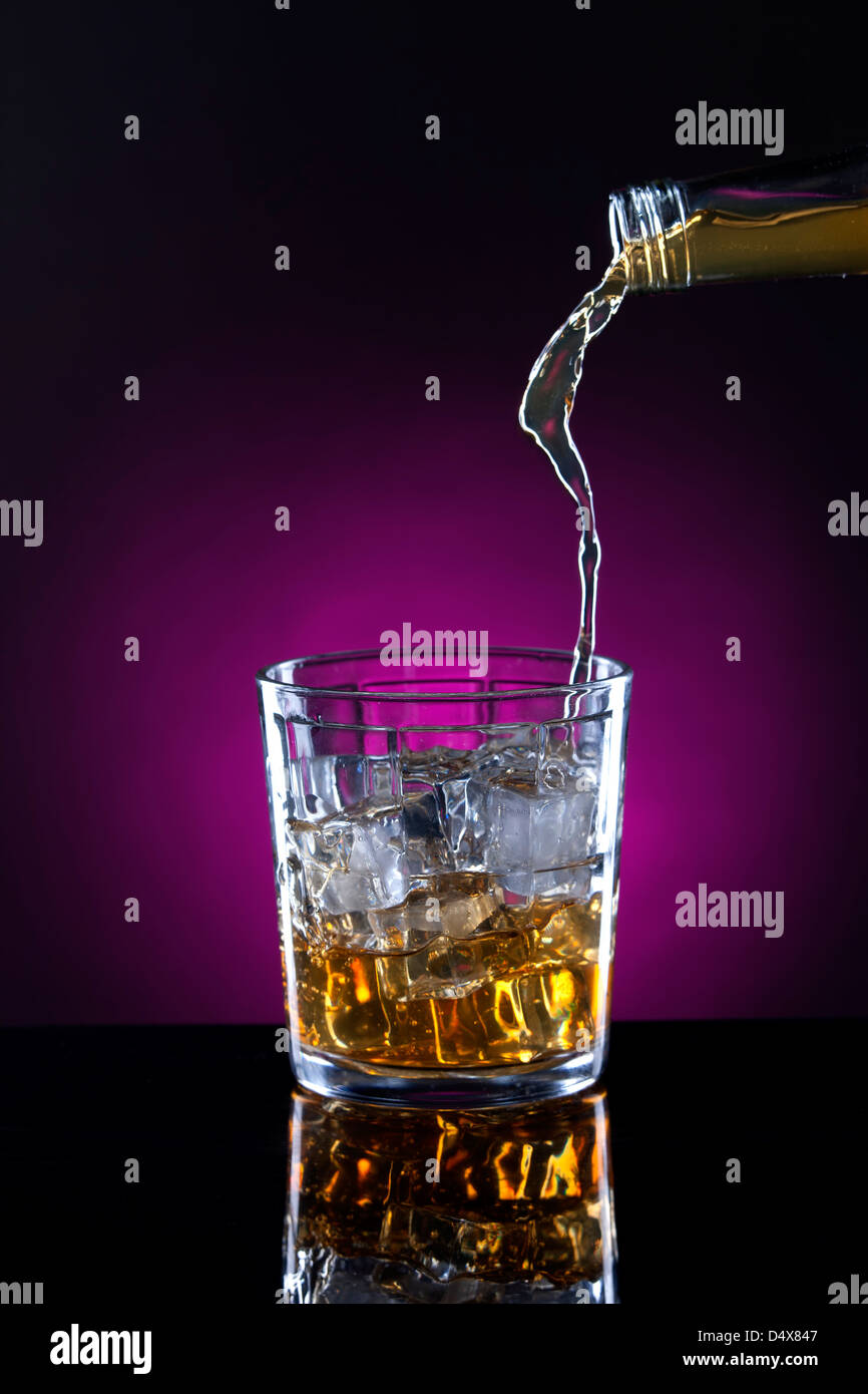 Slow stream of poured alcohol. Stock Photo