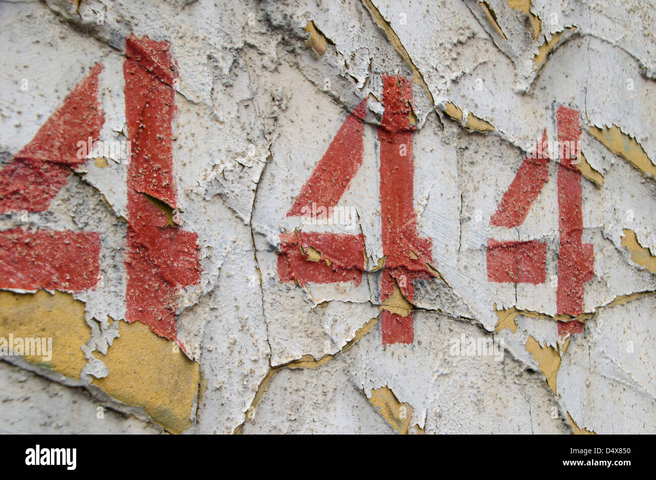 Abstract, gritty, urban background texture featuring a stenciled, painted '444' on a peeling white cement wall in Pittsburgh Stock Photo