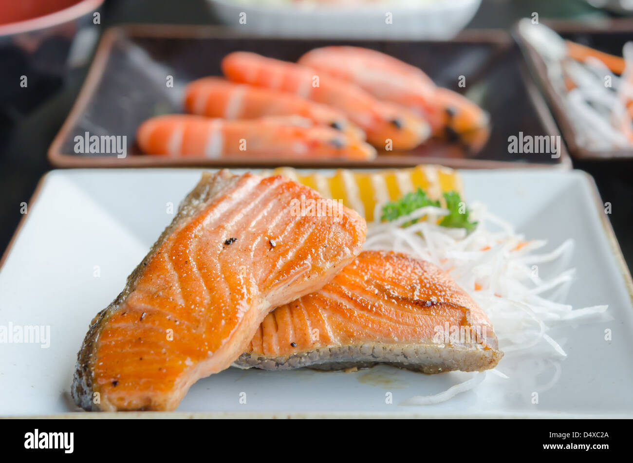two pieces of fish steak and fresh vegetable on white plate Stock Photo