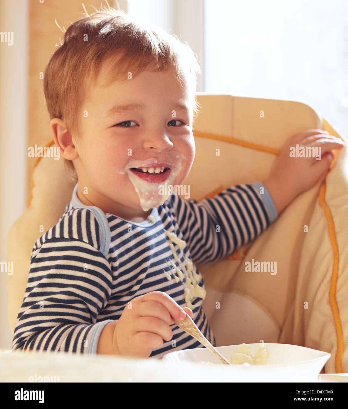Two year old boy smiles and eating porridge Stock Photo Alamy