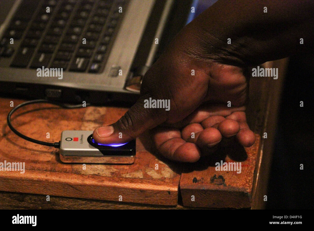 New Kihumbuini Primary School, Nairobi, Kenya - 4 March 2013: A voter places his thumb on a Biometric Voter Registration (BVR) reader at New Kihumbuini Primary School polling station. © David Mbiyu/Alamy Live News Stock Photo