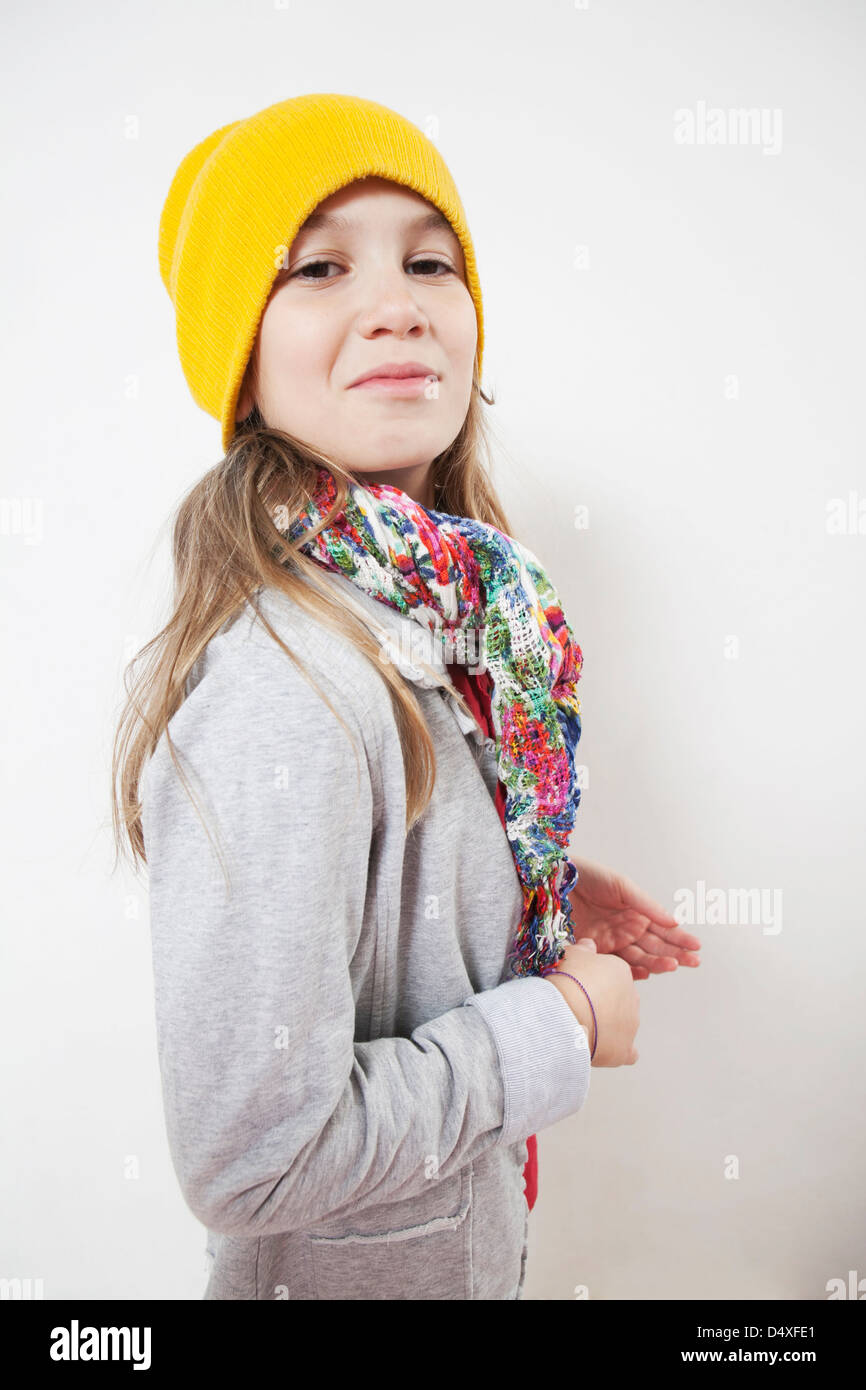 Silly little girl ten years old in yellow knitting hat with play