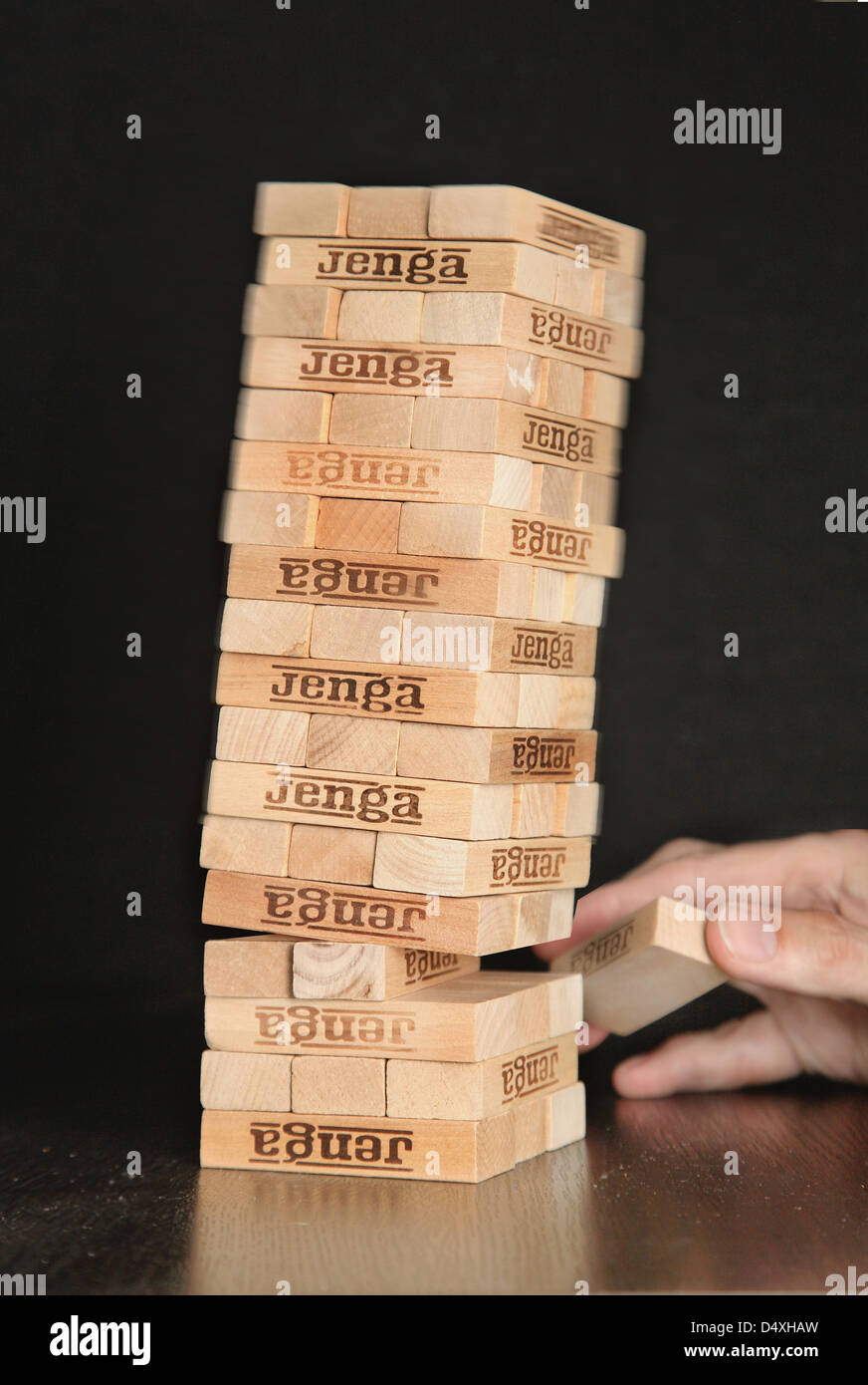 The game of Jenga. The tower of brick blocks collapses as one section is removed. Stock Photo