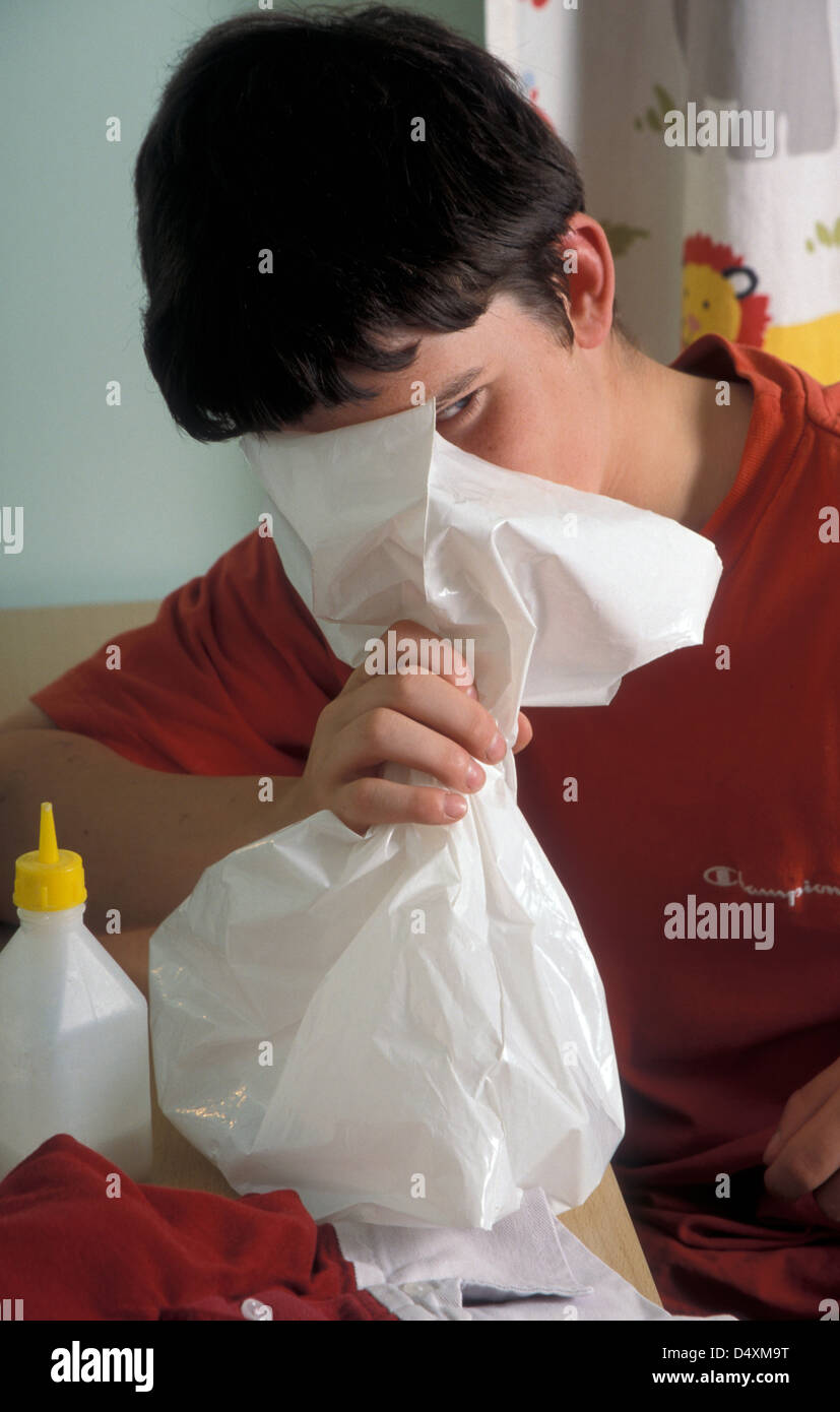 teenage inhaling glue from bag Stock Photo