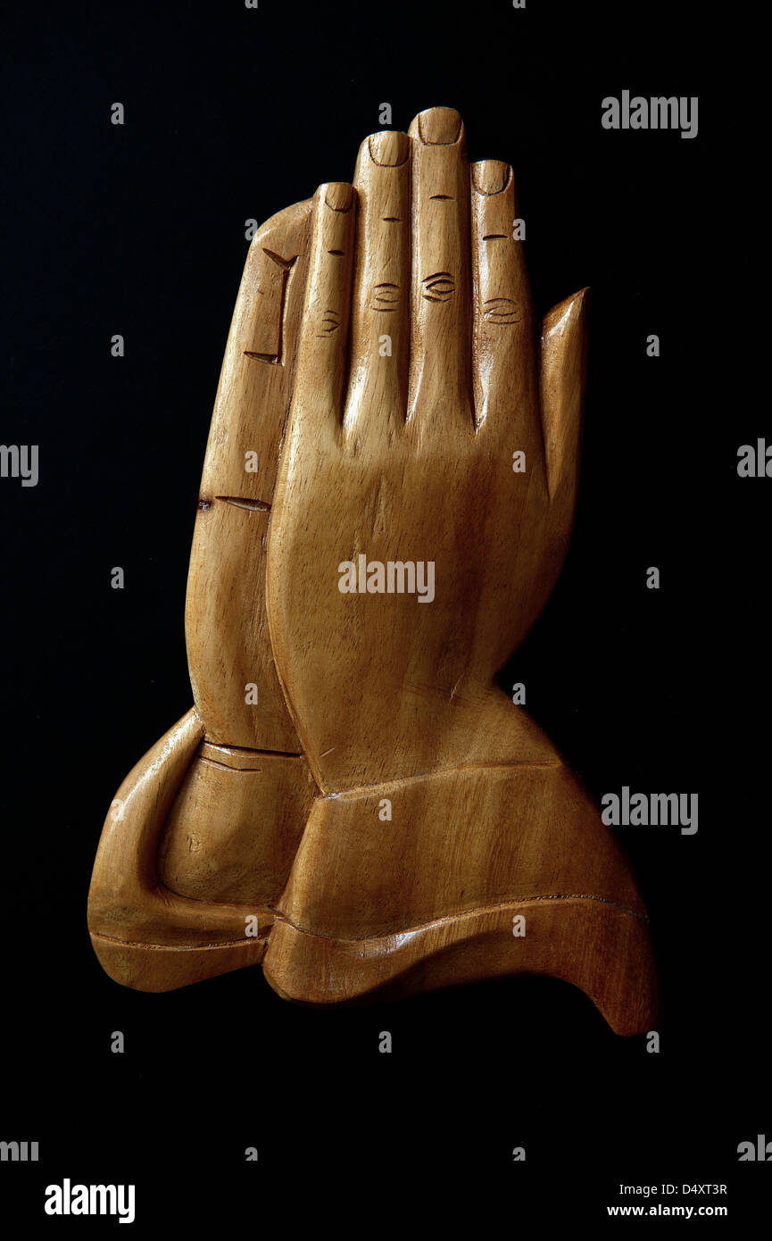 Creative still life image of wooden praying hands in black background. Dublin, Ireland. Stock Photo