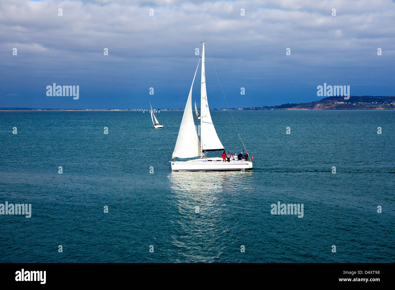 Landscape image of a yacht sailing in the ocean near Dun Laioghaire in Dublin, Ireland. Stock Photo