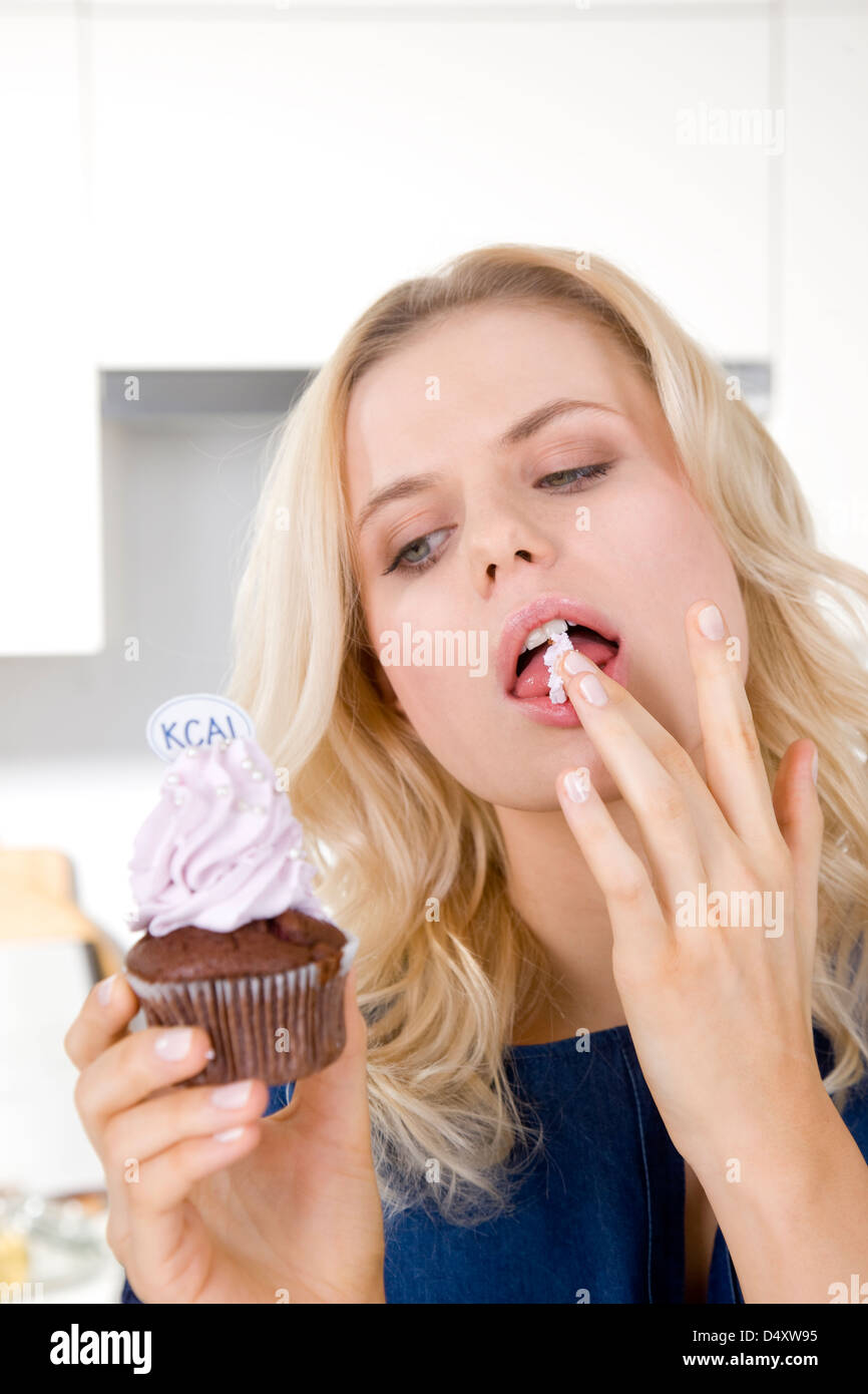Woman eating cupcake with cream Stock Photo Alamy
