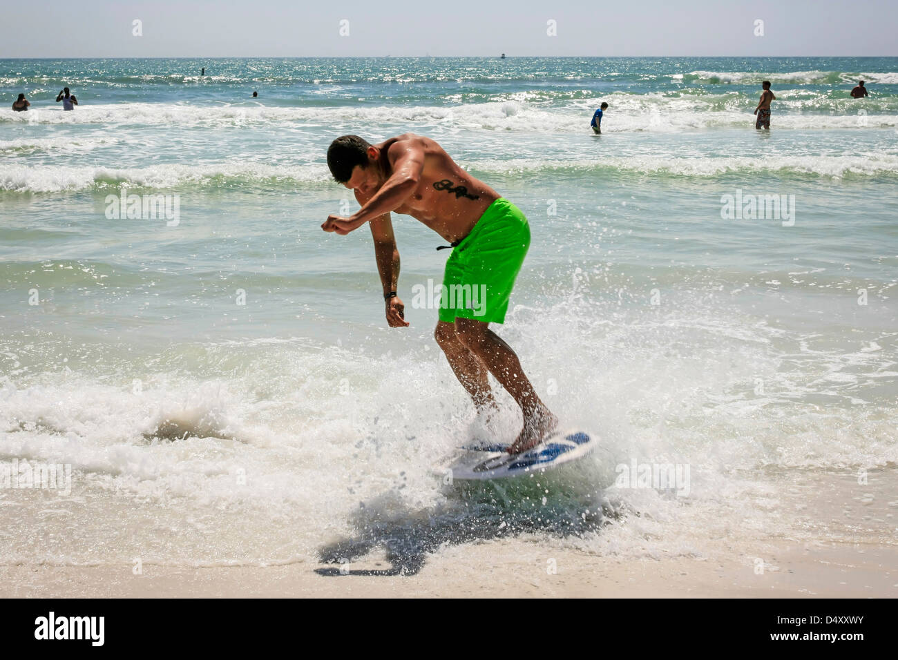 Male college student surfing along the waterfront on Siesta Key beach