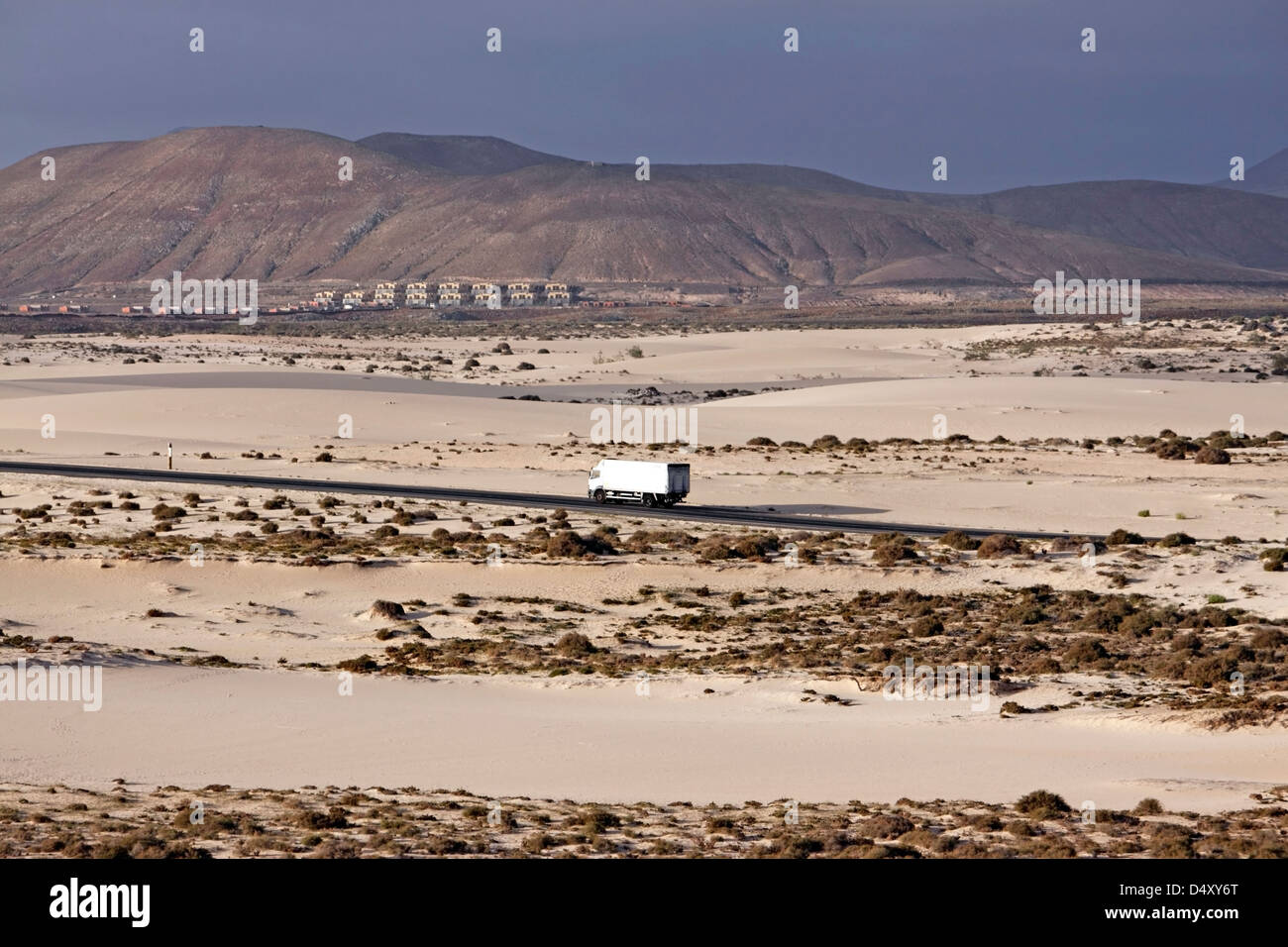 A TRUCK PASSES THROUGH THE DESERT LANDSCAPE OF CORRALEJO NATURAL PARK. FUERTEVENTURA. CANARY ISLAND. Stock Photo