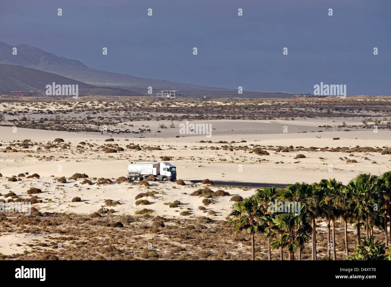 A TRUCK PASSES THROUGH THE DESERT LANDSCAPE OF CORRALEJO NATURAL PARK. FUERTEVENTURA. CANARY ISLAND. Stock Photo