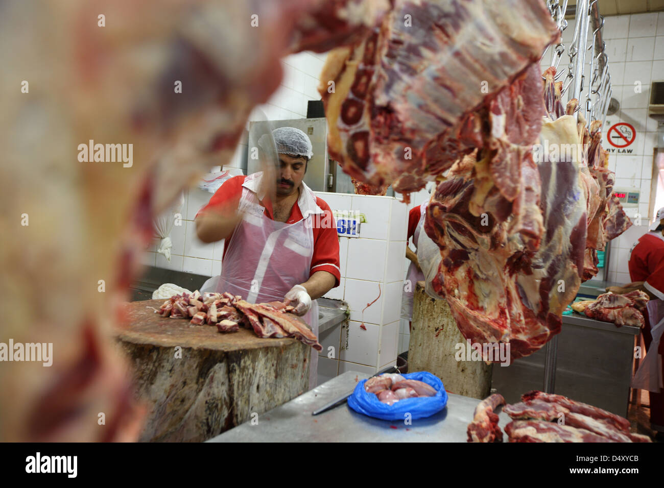 Man chopping meat at meat market, Dubai, United Arab Emirates Stock Photo