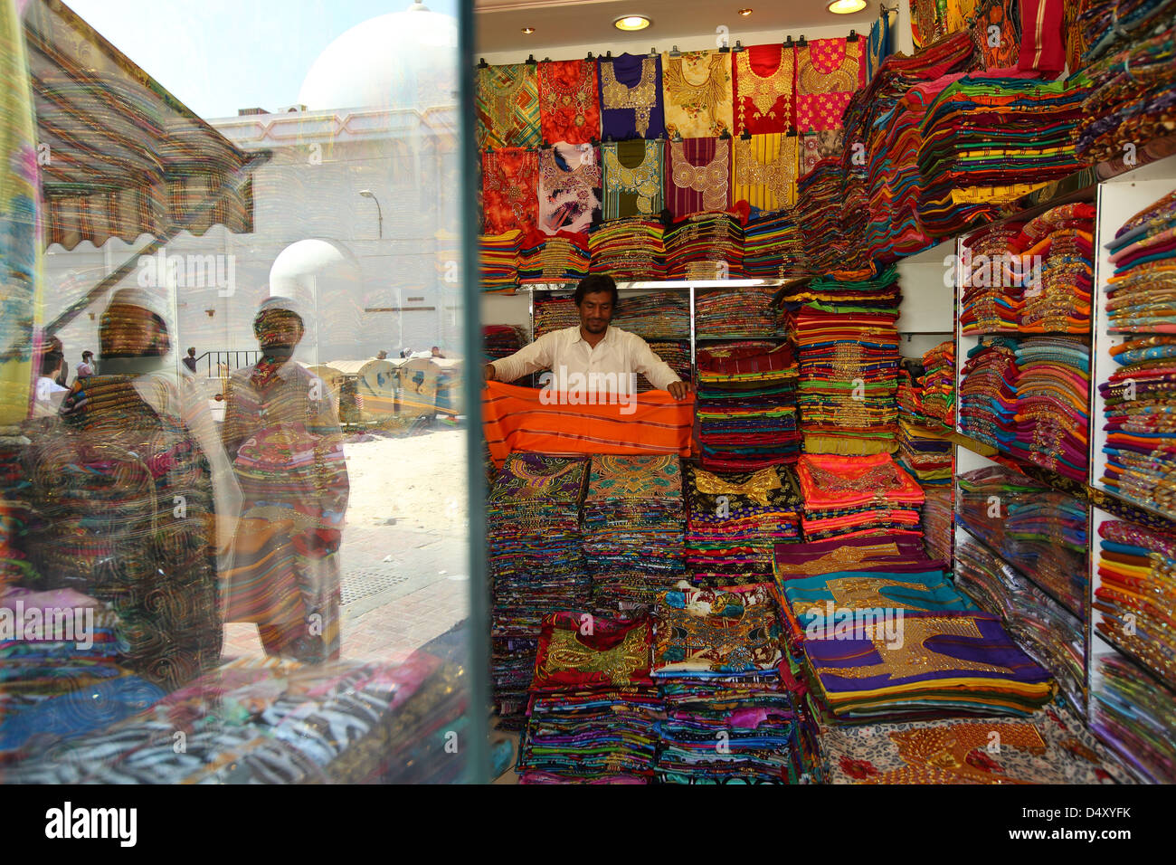 Man folding fabric in textile shop, Dubai, United Arab Emirates Stock Photo Alamy