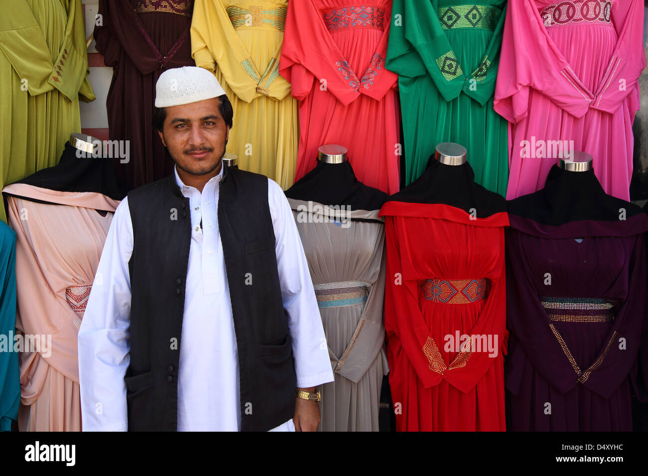 Portrait of shop owner by colorful clothing, Dubai, United Arab Emirates Stock Photo