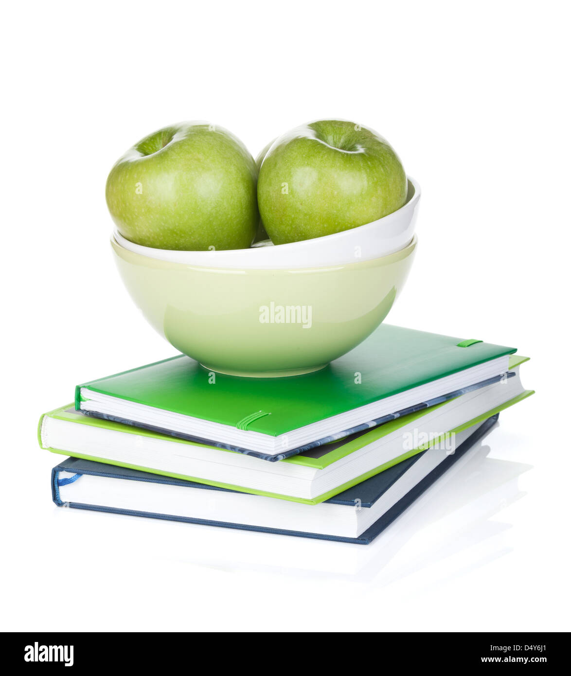 Green apples in fruit bowl and books. Isolated on white background