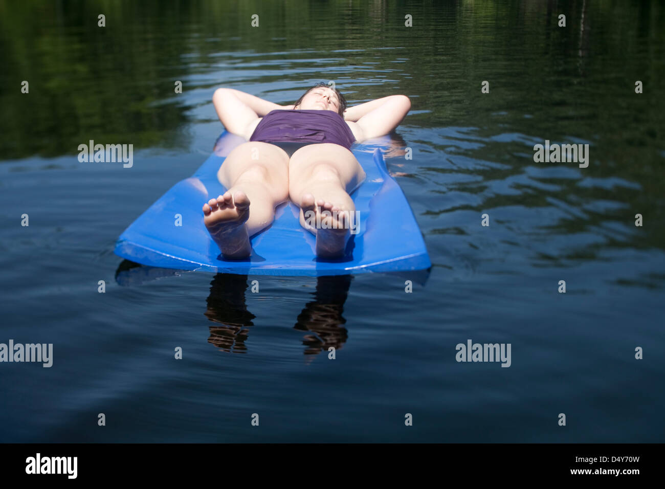 Woman on raft in lake relaxing Stock Photo Alamy