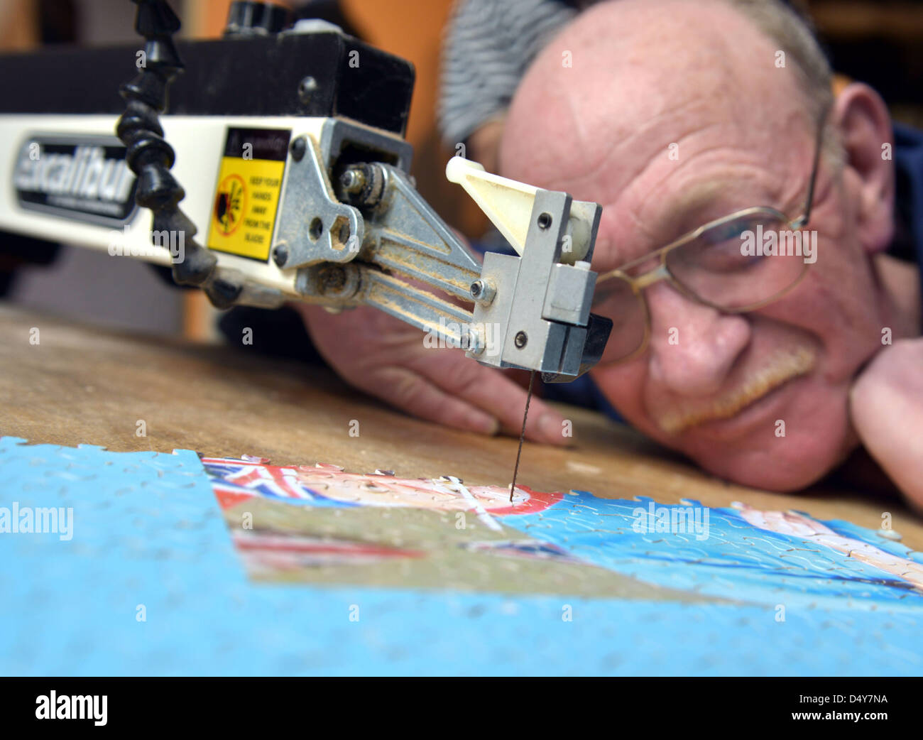 Weymouth, Dorset, UK. 20th March 2013. World record jigsaw attempt, Dave Evans at work on the largest wooden jigsaw in the world at Weymouth, Dorset, UK. The Queen's Diamond Jubilee jigsaw will take him weeks to cut out. Changing hundreds of blades and trying to keep his fingers away from the busy blade!. The 40,000 piece jigsaw will be around 3 metres by 4 metres when finished. 20th March, 2013 Picture by Geoff Moore/Dorset Media Service/Alamy Live News Stock Photo