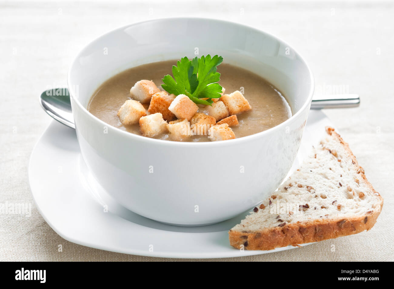 Mushroom soup with brown bread, croutons and fresh parsley Stock Photo