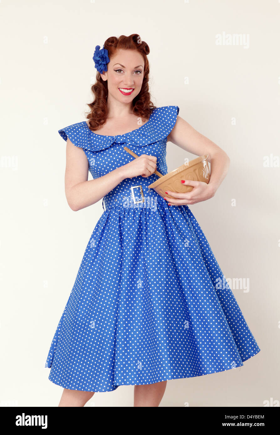 Woman in a vintage dress holding  a cookery mixing bowl Stock Photo
