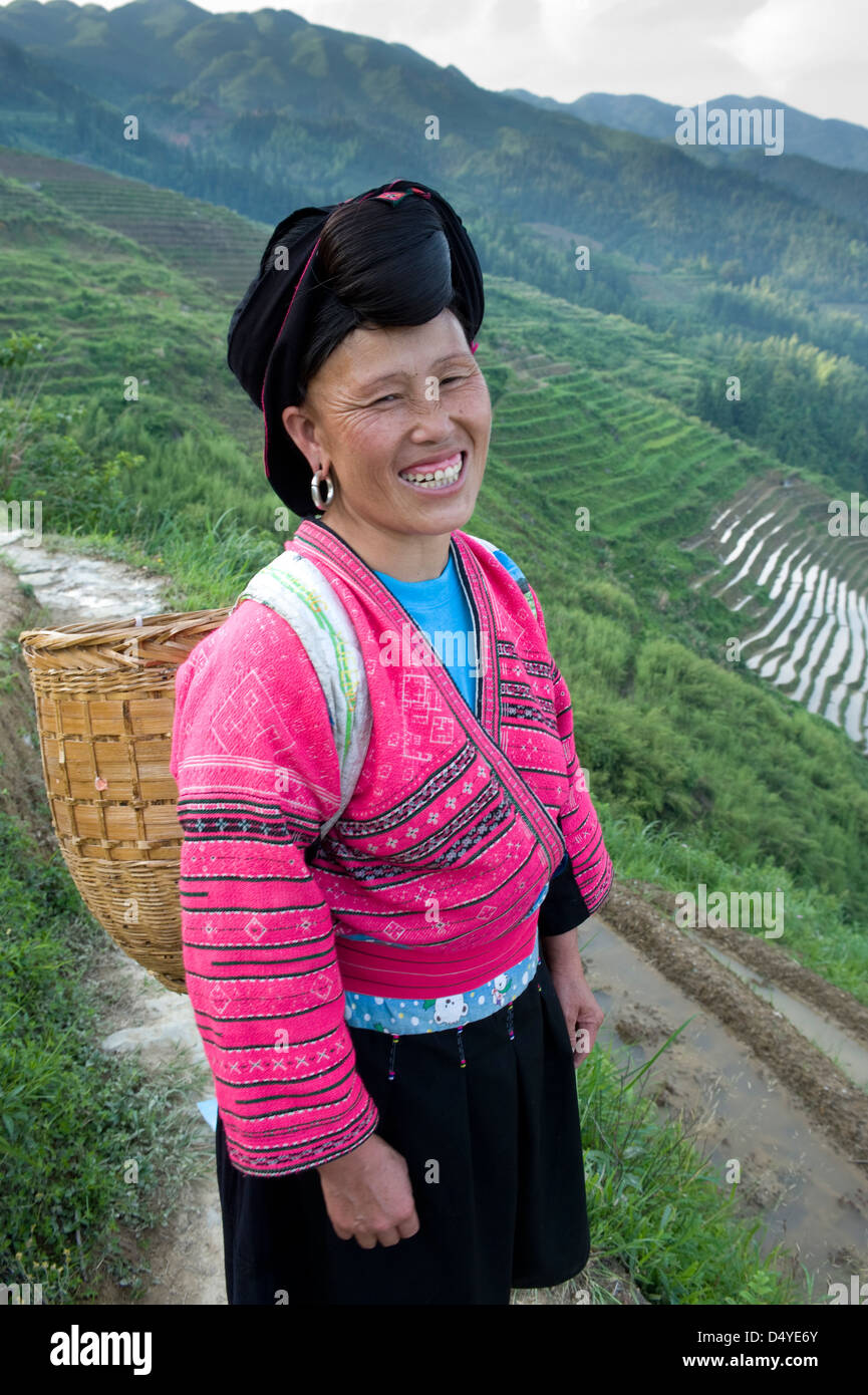 Yao Woman working in rice terraces, Dazhai Village, Dragon's Backbone Rice Terraces near Yao Guangxi Province China. (MR) Stock Photo