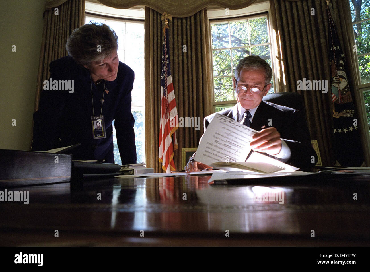 President George W. Bush looks over a brief with Karen Hughes, Counselor to the President, Monday, Oct. 8, 2001, in the Oval Office of the White House. Photo by Eric Draper, Courtesy of the George W. Bush Presidential Library Stock Photo