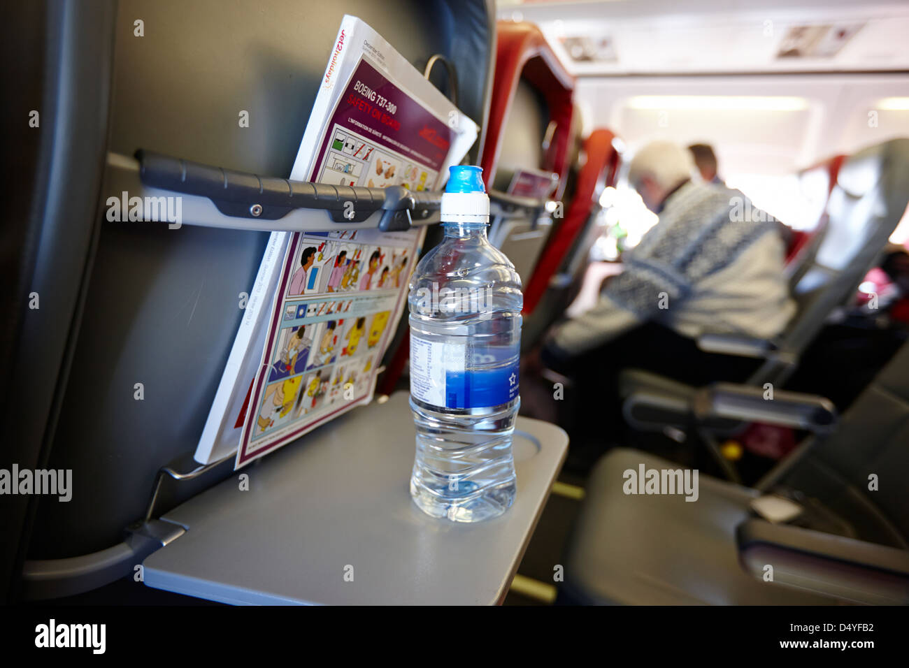 bottle of water on tray table interior of jet2 aircraft passenger cabin in flight europe Stock Photo