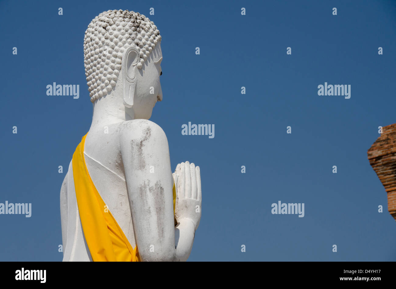 Thailand, Ayutthaya. Wat Phra Chao Phya-thai. Profile of Buddhist monk statue in yellow robe. UNESCO Stock Photo