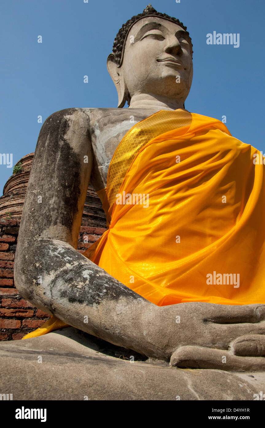 Thailand, Ayutthaya. Wat Phra Chao Phya-thai (aka Wat Yi Chai-mongkol). Seated Buddha statue in yellow robe. UNESCO Stock Photo
