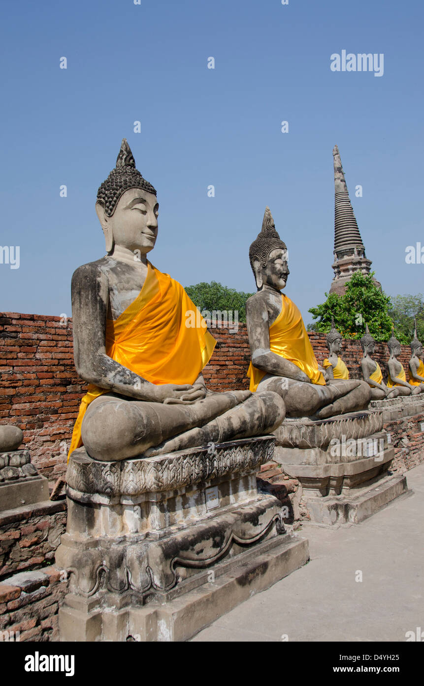Thailand, Ayutthaya. Wat Phra Chao Phya-thai. Line of seated Buddha statues dressed in yellow robes. UNESCO Stock Photo
