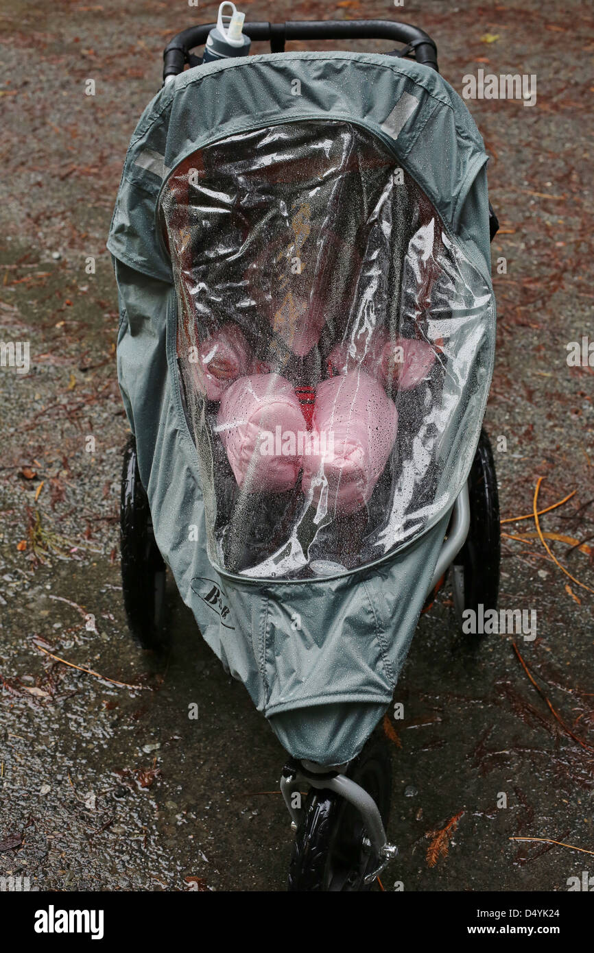 A baby in a water proof stroller on a rainy day. Stock Photo