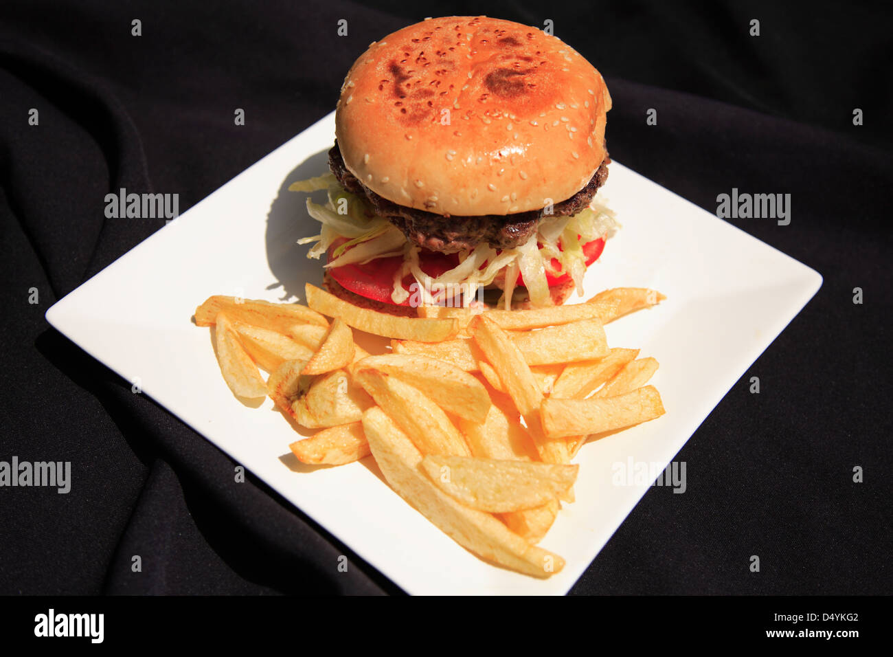 Beef burger and salad with fries on a white plate Stock Photo