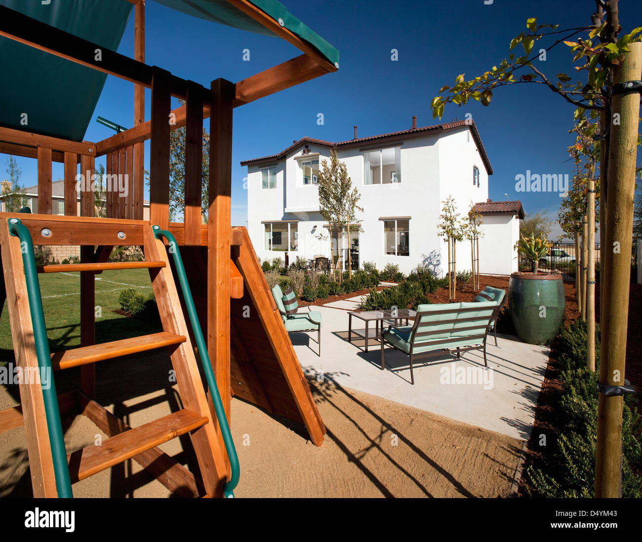 Swing set behind multiple story home, Palmdale, California, USA Stock Photo