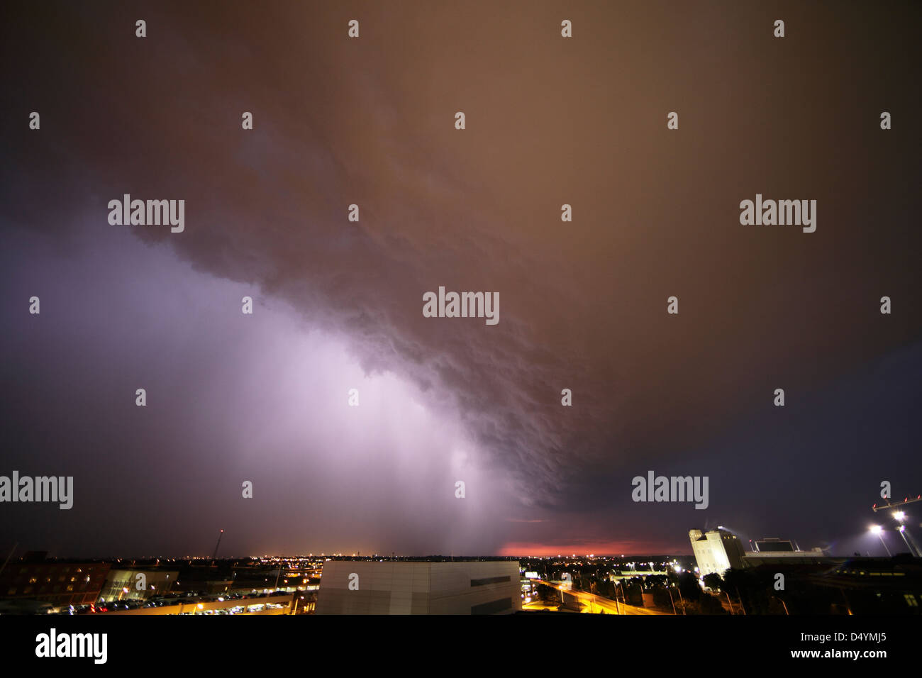Large nighttime storm, lit by lightning above city. Stock Photo