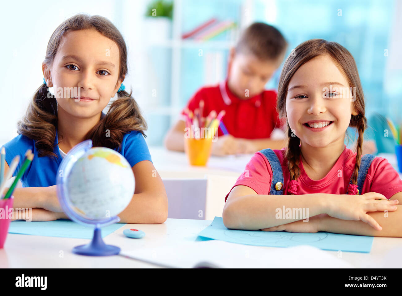 Portrait of cute school girls sitting at their desk Stock Photo - Alamy