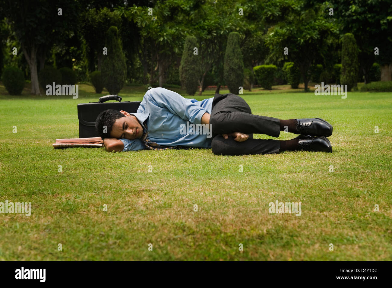 Businessman sleeping in a park Stock Photo Alamy