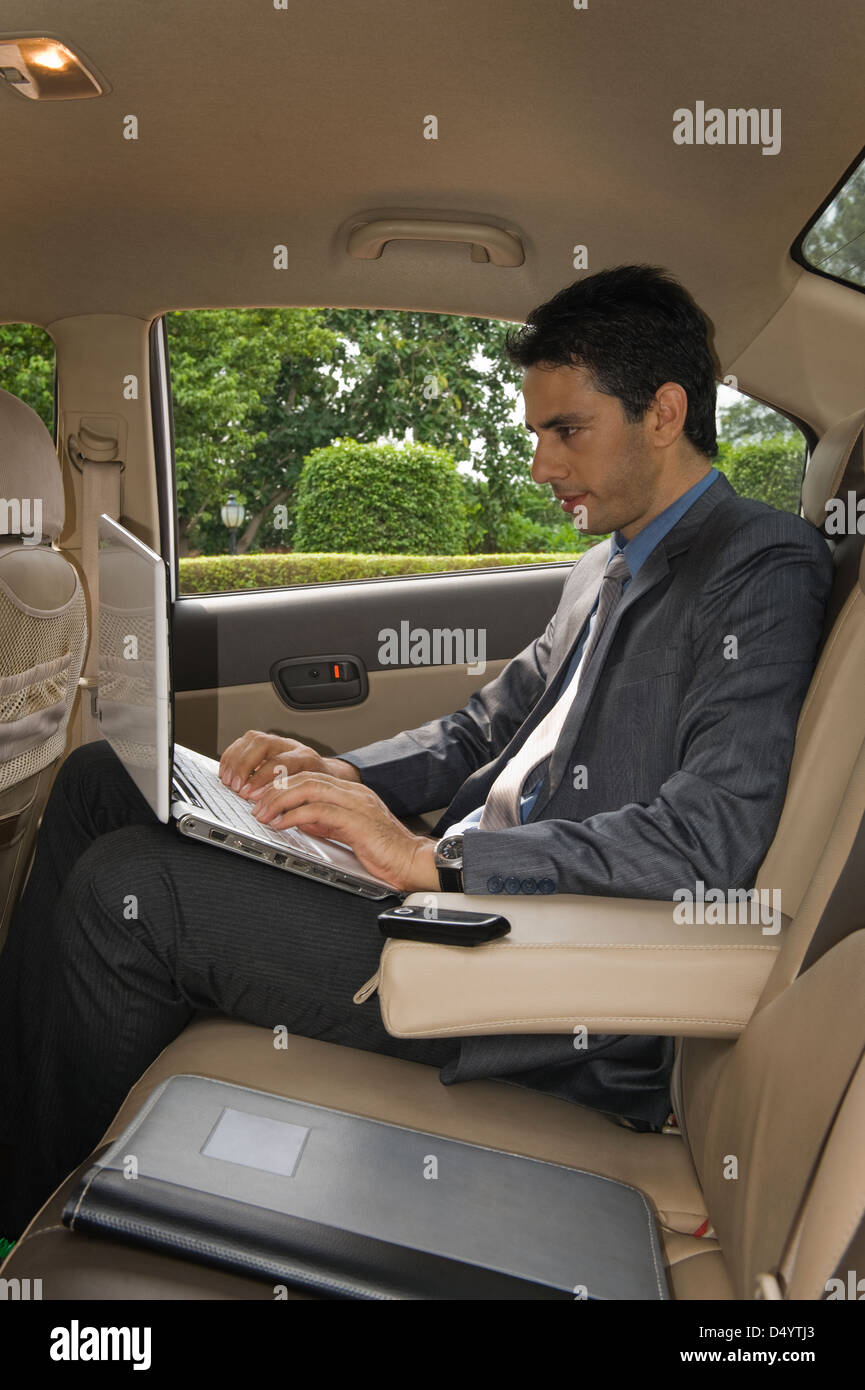 Businessman using a laptop in a car Stock Photo Alamy