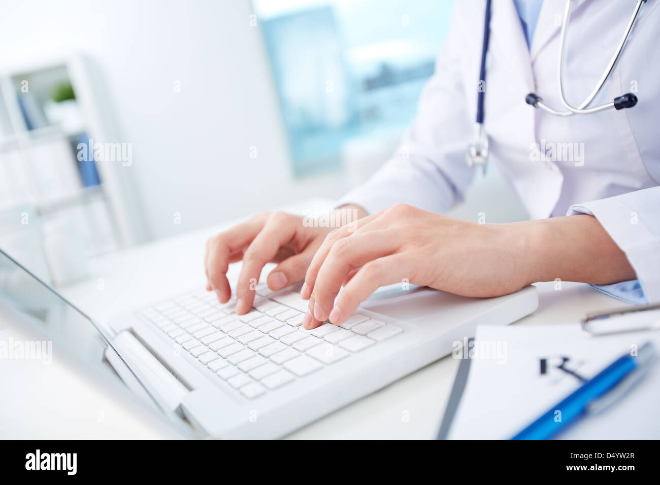 Modern doctor inputting diagnosis into online data base Stock Photo