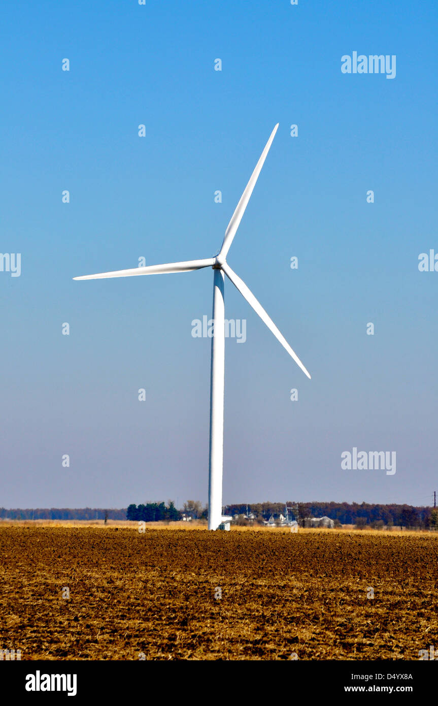 A windmill farm rotates over a Northwestern Indiana farm field Stock