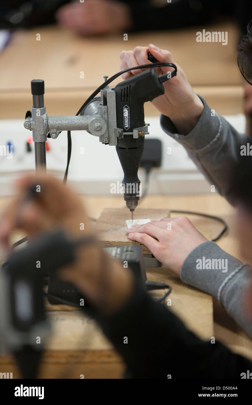 A student drills a circuit board during there electronics course at