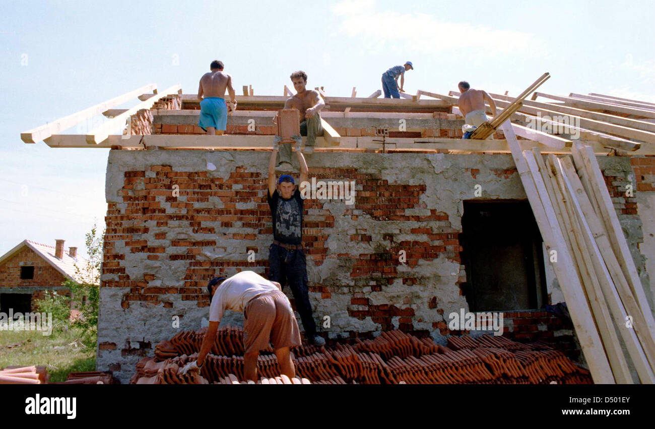 BRCKO, BOSNIA , 08 DECEMBER 1997 ---- Bosnian Moslem men rebuild their home in the contested Bosnian city of Brcko. Thousands of Moslems were ethnically cleansed from Brcko early on in the Bosnian conflict, but with NATO forces guaranteeing their safety many have returned. Stock Photo
