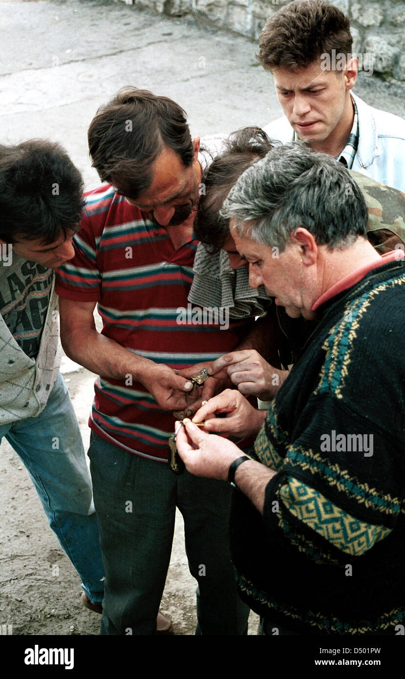 SARAJEVO, BOSNIA, 11 MARCH 1993 --- Bosnian army officials look over the identification tags of Bosnian soldiers recently exhumed from a mass grave. Stock Photo