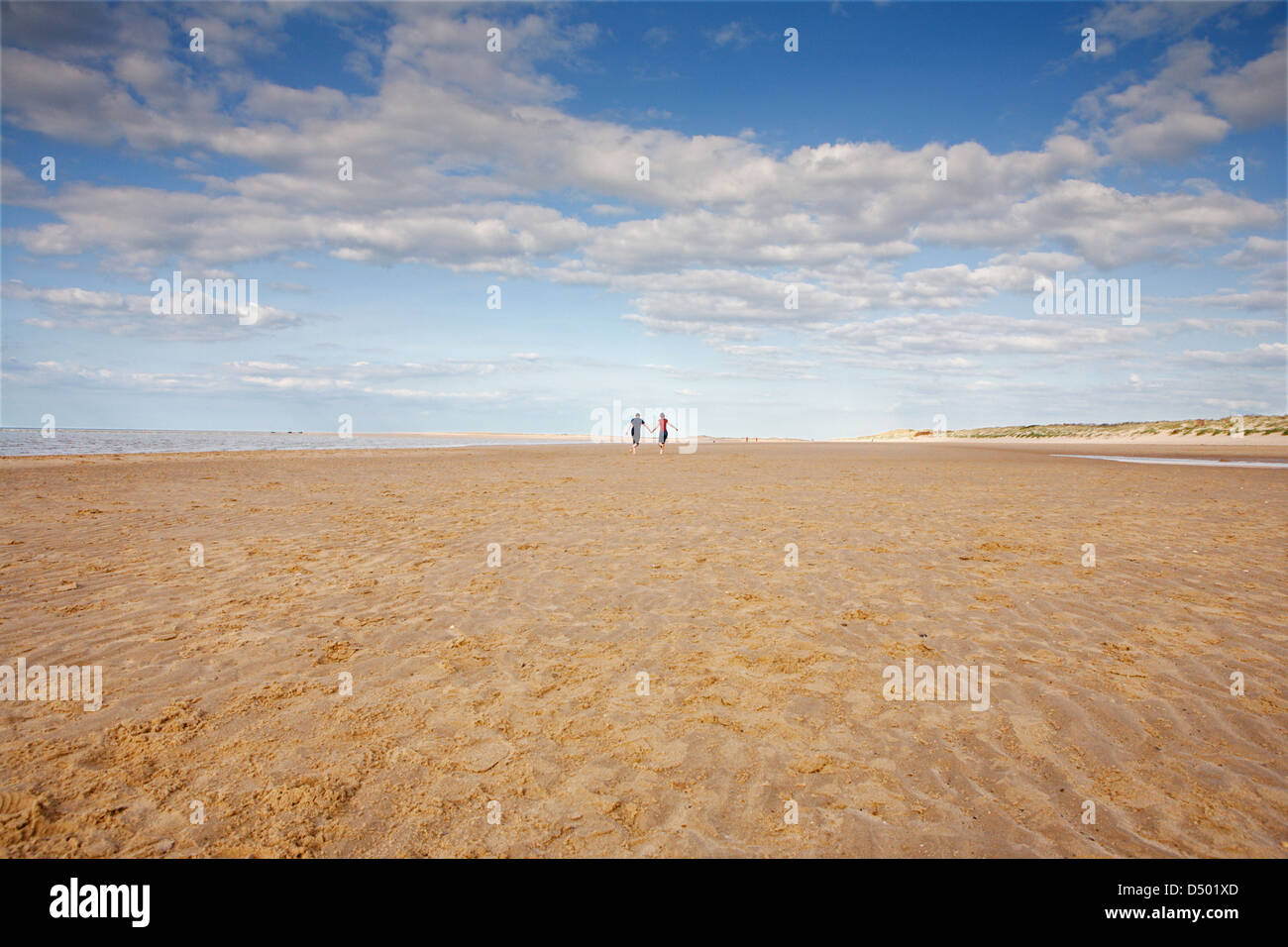 ENGLAND; NORFOLK; BRANCASTER; COUPLE; BEACH; RUNNING; LOVE; BIG SKY Stock Photo