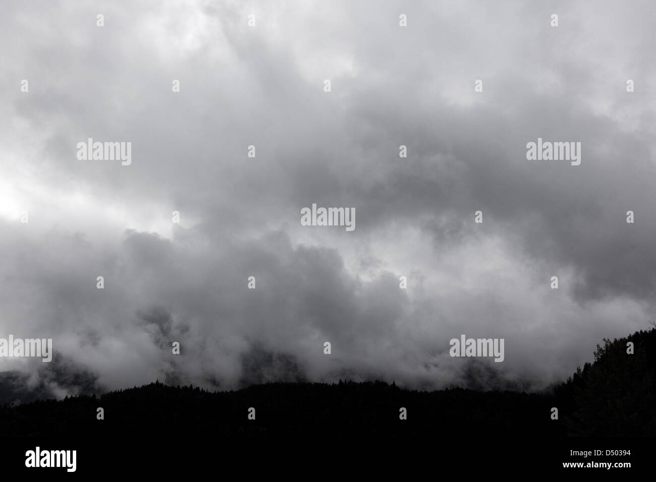 Grey clouds hover over the alpes. Stock Photo