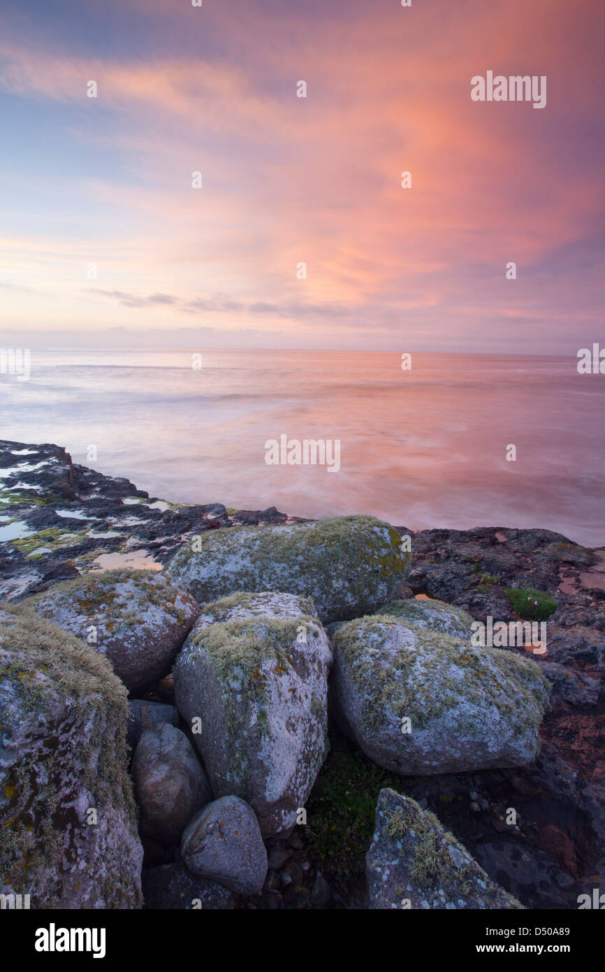 Sunset over coastal boulders at Easky, County Sligo, Ireland. Stock Photo