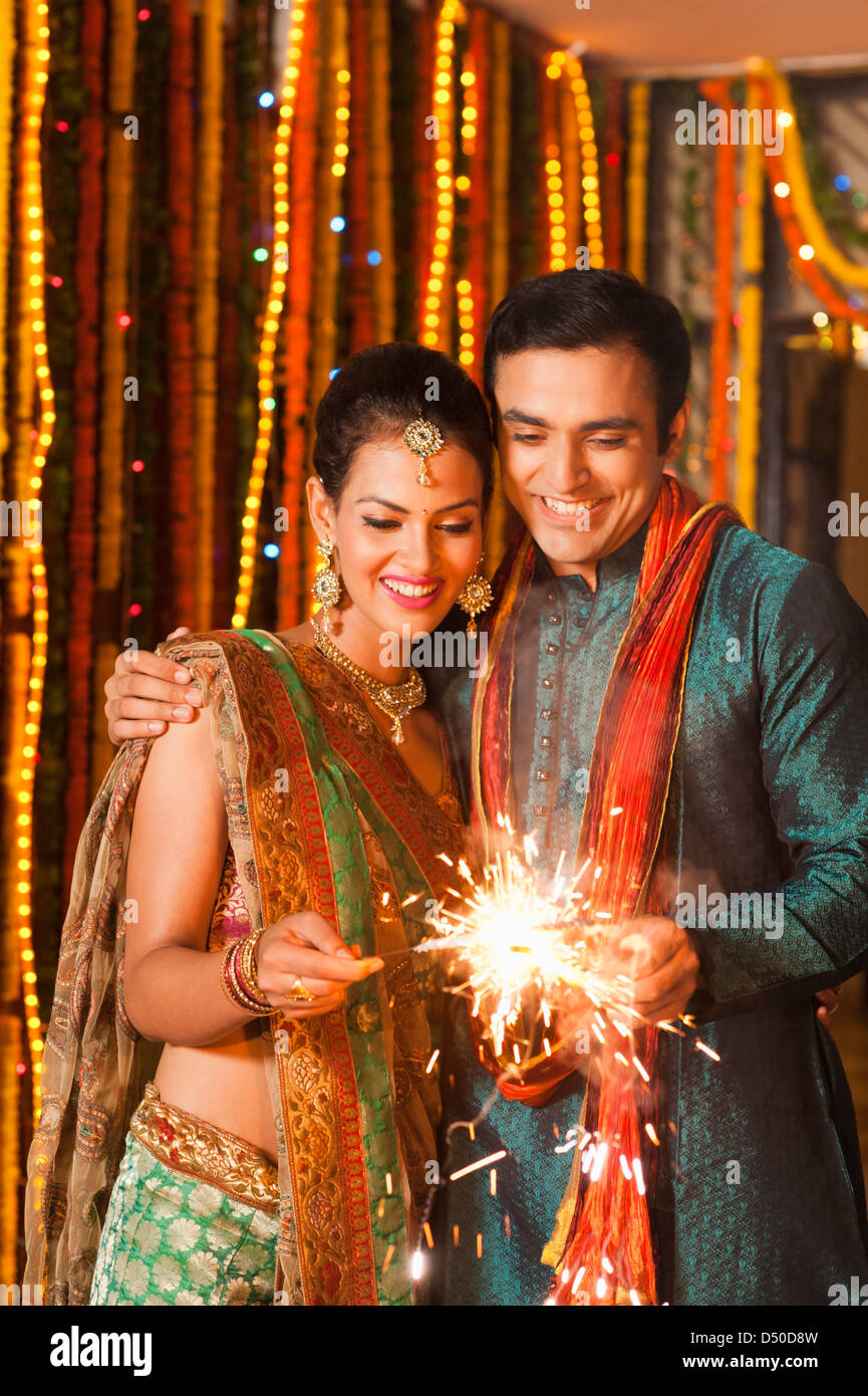 stock photo of cheerful young indian couple in traditional wear in diwali  over dark background with bokeh Stock Photo | Adobe Stock