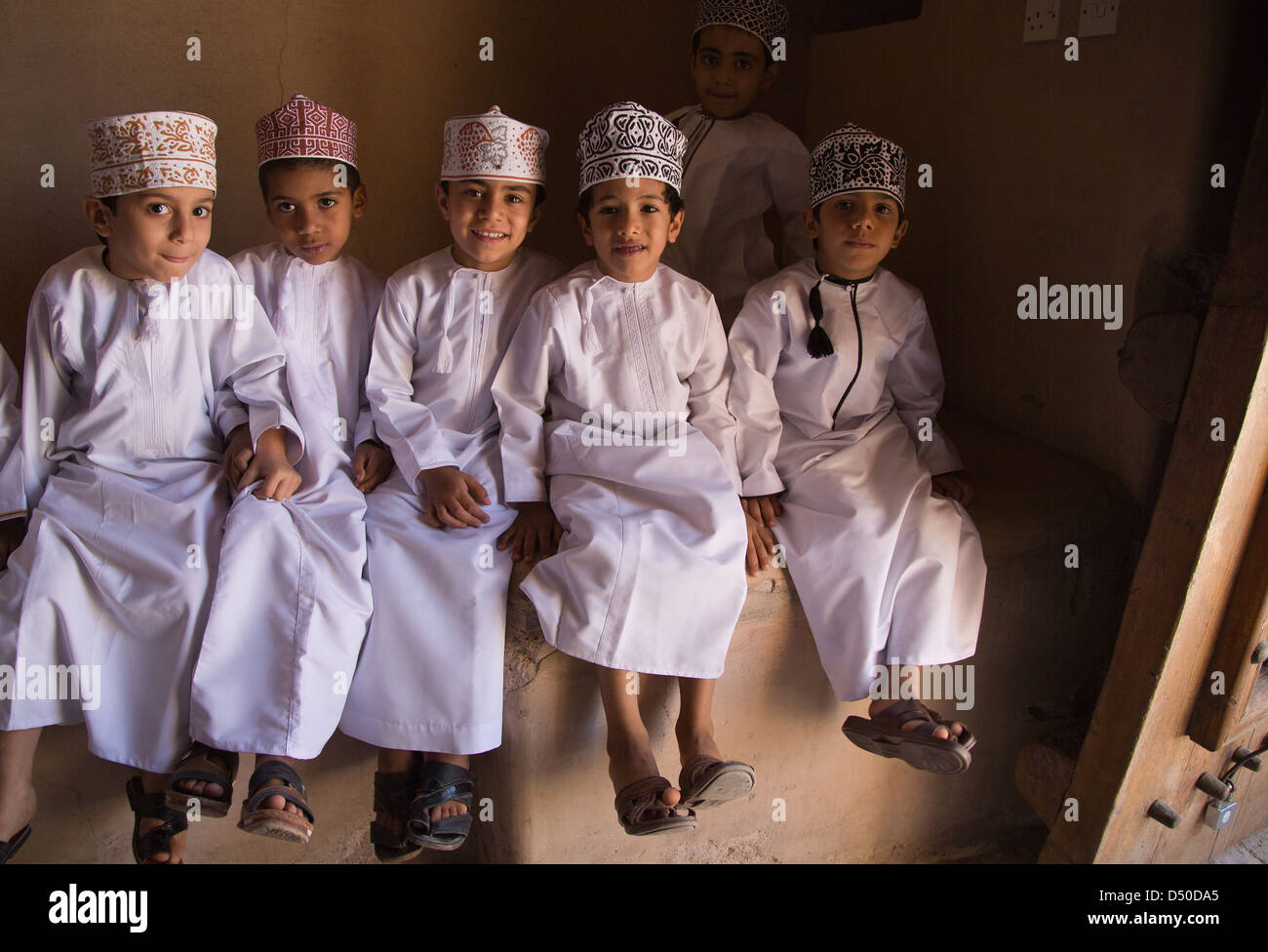 Omani Schoolboys wearing traditional dish dash and headdress on a school visit to the fort at Nizwa in Oman Stock Photo