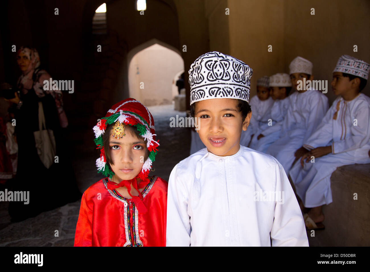 Young Omani school children in Traditional costumes on a school visit the Nizwa Fort in Oman Stock Photo